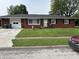 Charming single-story red brick home with a well-maintained front yard and attached garage at 1422 Dallas Dr, Plainfield, IN 46168