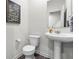 Powder room with pedestal sink, neutral walls, and stylish artwork, for a touch of elegance and charm at 14350 Ludwell Ct, Fishers, IN 46037