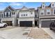Exterior view featuring a row of townhomes with garages, paved driveways, and professionally landscaped yards at 14350 Ludwell Ct, Fishers, IN 46037