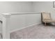 Upstairs hallway with neutral carpet, white trim, and traditional chair at 14350 Ludwell Ct, Fishers, IN 46037