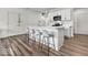 Bright kitchen featuring white cabinets, stainless steel appliances, an island with seating and wood-look floors at 14350 Ludwell Ct, Fishers, IN 46037