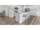 Modern kitchen with white cabinetry, stainless steel appliances, hardwood floors and island with bar stool seating at 14350 Ludwell Ct, Fishers, IN 46037