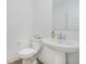 Clean and modern powder room featuring a pedestal sink, toilet, and crisp white walls at 1510 Stonehaven Dr, Westfield, IN 46074