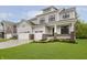 Inviting two-story home featuring a three-car garage, professional landscaping, and neutral-colored siding at 1510 Stonehaven Dr, Westfield, IN 46074