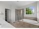 Bathroom featuring a soaking tub, a glass-enclosed shower, and a large window at 15292 Slateford Rd, Noblesville, IN 46062