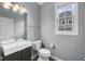Powder room featuring gray walls, modern vanity, toilet, and a window at 15292 Slateford Rd, Noblesville, IN 46062
