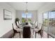 Bright dining room featuring a glass-top table, seating for eight, and sliding glass doors to the deck at 15292 Slateford Rd, Noblesville, IN 46062