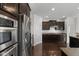 Modern kitchen with stainless steel appliances, dark cabinets, granite countertops, and hardwood floors at 15292 Slateford Rd, Noblesville, IN 46062
