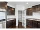 Modern kitchen with stainless steel appliances, dark cabinets, granite countertops, hardwood floors, and a pantry at 15292 Slateford Rd, Noblesville, IN 46062