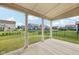 Inviting covered back porch with view of expansive backyard and neighboring houses at 15418 Tattersalls Ln, Fishers, IN 46040