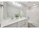 Bathroom featuring a double sink vanity, large mirror, and shower-tub combo with tile surround at 15418 Tattersalls Ln, Fishers, IN 46040