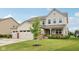 Charming two-story home featuring a three-car garage and well-manicured lawn at 15418 Tattersalls Ln, Fishers, IN 46040