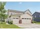 Charming two-story home featuring a three-car garage and well-manicured lawn at 15418 Tattersalls Ln, Fishers, IN 46040