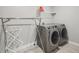 Modern laundry room with front-load washer and dryer set, and wire shelving, maximizing functionality at 15418 Tattersalls Ln, Fishers, IN 46040