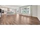 Spacious living room featuring hardwood floors, natural light, and an open floor plan into the kitchen area at 15418 Tattersalls Ln, Fishers, IN 46040