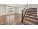 Bright living room with large windows, wood floors, and a staircase at 15418 Tattersalls Ln, Fishers, IN 46040