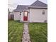 A charming backyard features a stone pathway leading to a house with a red door at 179 E Pearl St, Greenwood, IN 46143