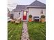 Backyard features manicured lawn, stone pathway, modern outdoor furniture, grill, and landscaped garden at 179 E Pearl St, Greenwood, IN 46143