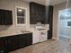 Charming kitchen features dark cabinets, stainless steel sink and white appliances at 179 E Pearl St, Greenwood, IN 46143