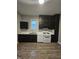 Functional kitchen with dark cabinets, white appliances, and modern backsplash at 179 E Pearl St, Greenwood, IN 46143