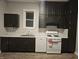 Charming kitchen features dark cabinets, stainless steel sink and white appliances at 179 E Pearl St, Greenwood, IN 46143