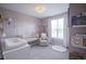 Charming Bedroom with soft pink walls, white crib, accent chair, and plush carpet, perfect for a baby's room at 19144 Goins Blvd, Westfield, IN 46074