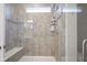 Modern shower featuring neutral tile, seamless glass enclosure, built-in bench, and a window for natural light at 19144 Goins Blvd, Westfield, IN 46074