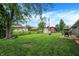 Picturesque backyard with green grass, mature trees, outdoor seating, and storage shed at 200 Forum Dr, Whiteland, IN 46184