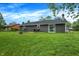 Spacious backyard featuring a well-maintained lawn, patio area and mature trees at 200 Forum Dr, Whiteland, IN 46184