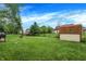 Well-maintained backyard featuring lush grass, a storage shed, and mature trees at 200 Forum Dr, Whiteland, IN 46184