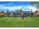 Expansive backyard with a lush green lawn, patio with seating, and mature landscaping at 200 Forum Dr, Whiteland, IN 46184