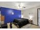 A bedroom featuring a blue accent wall, ceiling fan, and two bedside lamps at 200 Forum Dr, Whiteland, IN 46184