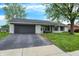 Charming single-story brick home with an attached garage and seating on the front porch at 200 Forum Dr, Whiteland, IN 46184