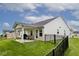 Back exterior view showcasing a covered patio perfect for outdoor enjoyment and a black-fenced yard at 200 Mission Terrace Dr, Whiteland, IN 46184