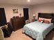 A serene bedroom featuring a bed with a quilted blue coverlet, a dark wood dresser, and ambient lighting at 200 Mission Terrace Dr, Whiteland, IN 46184