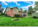 Beautiful backyard with a lush lawn, patio seating, mature trees, and a custom-built play structure at 201 Angela Ct, Noblesville, IN 46062