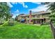 Large backyard featuring a sprawling lawn, a custom play structure, patio seating, and mature trees at 201 Angela Ct, Noblesville, IN 46062