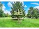 Fenced backyard boasting a sprawling green lawn and a custom-built play structure for outdoor fun at 201 Angela Ct, Noblesville, IN 46062