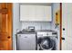 Efficient laundry area with a washer, dryer, and overhead storage cabinets, ideal for modern convenience at 201 Angela Ct, Noblesville, IN 46062