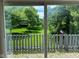 Backyard view with green grass, mature trees and a gray fence at 213 Golf Ct, Greenwood, IN 46143
