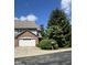 Exterior view showcasing the home's brick and siding details, mature trees, and driveway at 213 Golf Ct, Greenwood, IN 46143