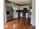 Bright kitchen featuring stainless steel appliances, white cabinets, and hardwood floors at 213 Golf Ct, Greenwood, IN 46143