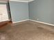 Living room with carpet flooring, neutral walls, and a door to a staircase at 213 Golf Ct, Greenwood, IN 46143