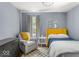 A well-lit bedroom with a yellow headboard, comfortable chair, and neutral paint at 2521 Mcleay Dr, Indianapolis, IN 46220