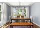 A modern dining room featuring a wooden table, bench, and views to the exterior at 2521 Mcleay Dr, Indianapolis, IN 46220