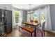 A sunlit dining room featuring a modern table, bench, and sleek black refrigerator at 2521 Mcleay Dr, Indianapolis, IN 46220