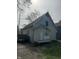 Rear exterior view of a weathered two-story home with a small porch and overgrown yard at 330 N Lasalle St, Indianapolis, IN 46201