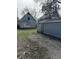 View of the backyard, house, and detached garage, showing potential landscaping and renovation needs at 330 N Lasalle St, Indianapolis, IN 46201