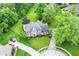 Aerial view of a brick house with lush landscaping, a circular driveway, and mature trees at 3772 Christina Ct, Carmel, IN 46033