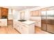 Open kitchen with stainless steel refrigerator, gas cooktop island, and seamless flow into adjacent living space at 3772 Christina Ct, Carmel, IN 46033